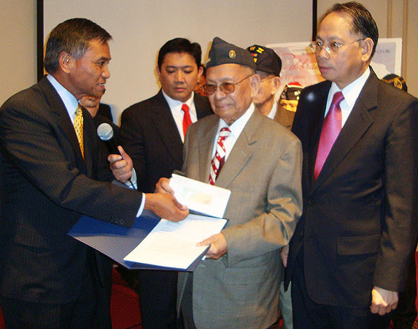 Alberto Bacani receives the first check from the equity from Maj. Gen. Tony Taguba - Photo: ACFV.