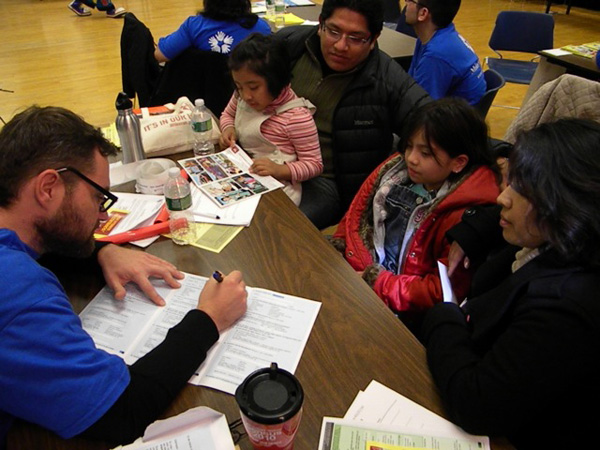 A volunteer helps a Mexican-American family fill out their census form at an event in Queens, NY to encourage immigrant participation in the 2010 Census - Photo: John Rudolph.
