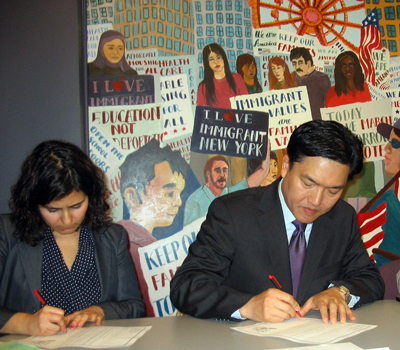 Martha Chavez and S.J. Jung signing letters to President Obama