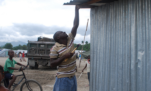 A man repairing his roof in Haiti - Photo: Oxfam International