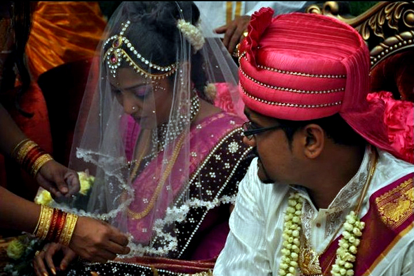 Bridesmaid adjusts bride's veil
