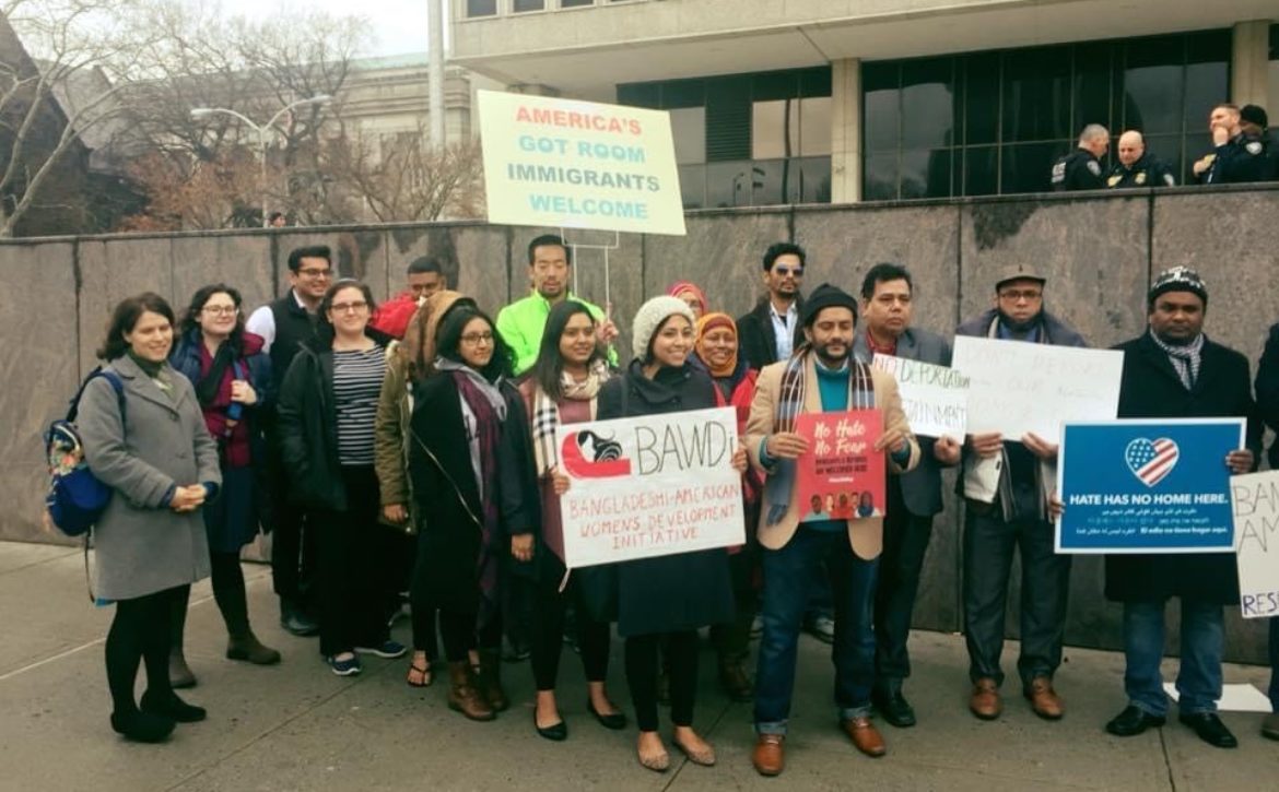 A group of Desi-American activists don signs of welcome to immigrants