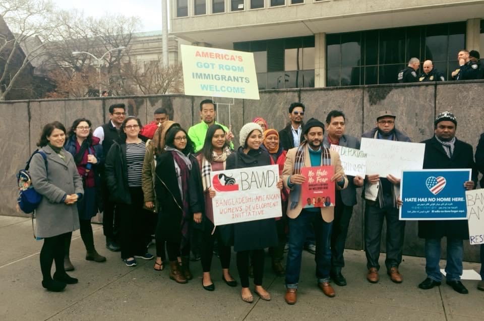 A group of Desi-American activists don signs of welcome to immigrants
